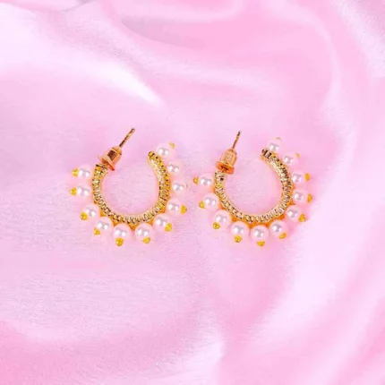 "Gold huggie hoop earrings with small white pearl drops, polished finish, and push‑back closure. "