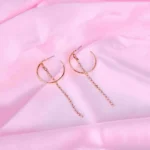 Gold hoop earrings with rhinestone chain drops, featuring polished half hoops and cascading crystals.