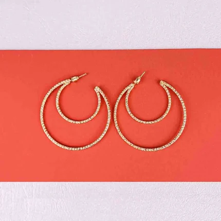 Gold layered hoop earrings with textured polished finish and push‑back closure, featuring three interlaced arcs for a sculptural look.