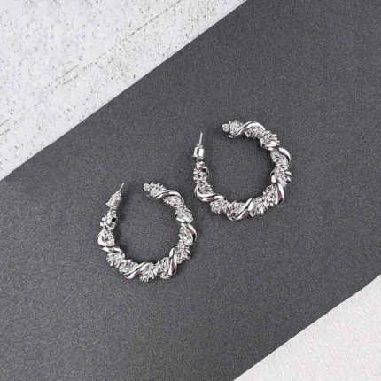  Sculpted textured hoop earrings with organic finish and secure push back closure, displayed on earring cards.