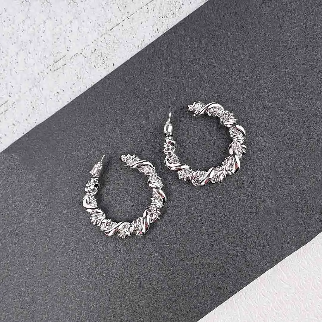 20251106_155427 Sculpted textured hoop earrings with organic finish and secure push back closure, displayed on earring cards.