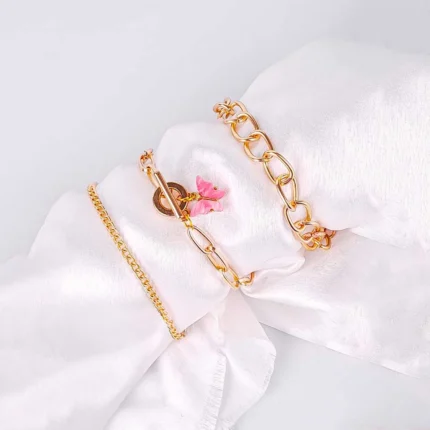 Three gold chain bracelets, one with large links, one classic, one with a pink butterfly charm and adjustable closures.