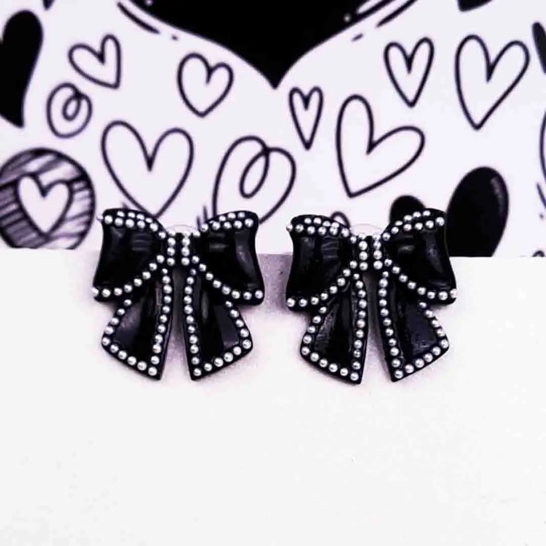 TH-617 (1) Elegant black bow-shaped earrings outlined with white pearls and featuring a secure push-back closure.