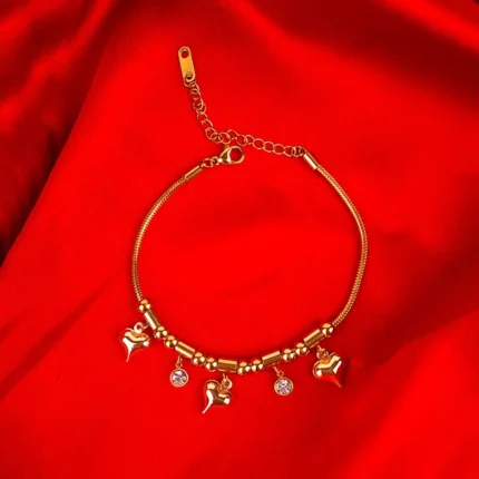  Gold bracelet with heart and bead charms on flexible snake chain.